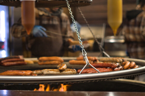 Würstchen auf einem Schwenk-Grill © Adobe Stock // Miquel