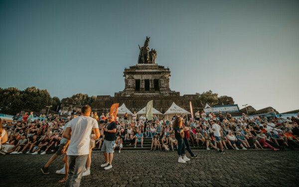 Rhein in Flammen-61-1000x629.jpg © Koblenz-Touristik, Janko. Media
Menschen sitzen am Deutschen Eck © Koblenz-Touristik, Janko. Media